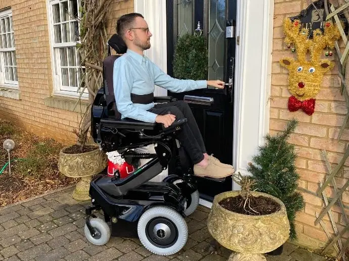 Charlie, sitting in his Balder F380, opening his front door